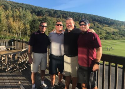 four men posing for a photo at a golf course