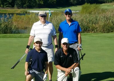 four men posing for a photo on a golf course