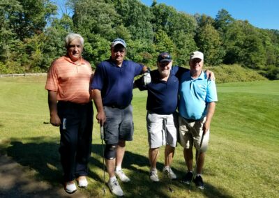 four men posing for a photo on a golf course