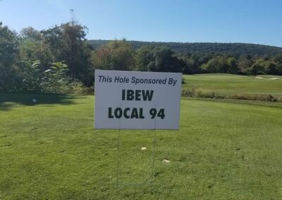 sign on a golf course that reads "This hole sponsored by IBEW Local 94"