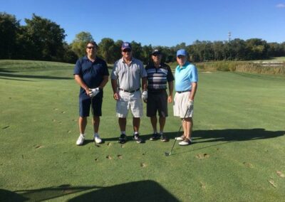 four men posing for a photo on a golf course