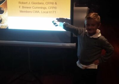 a young boy pointing at a sign